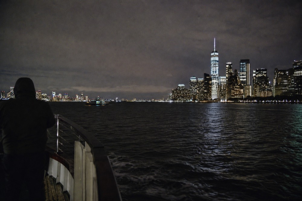 View from a boat deck looking north up the Hudson River with Midtown towers on the right and open water ahead in late afternoon